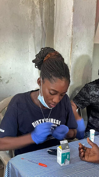 Volunteers checking blood glucose level at a community outreach